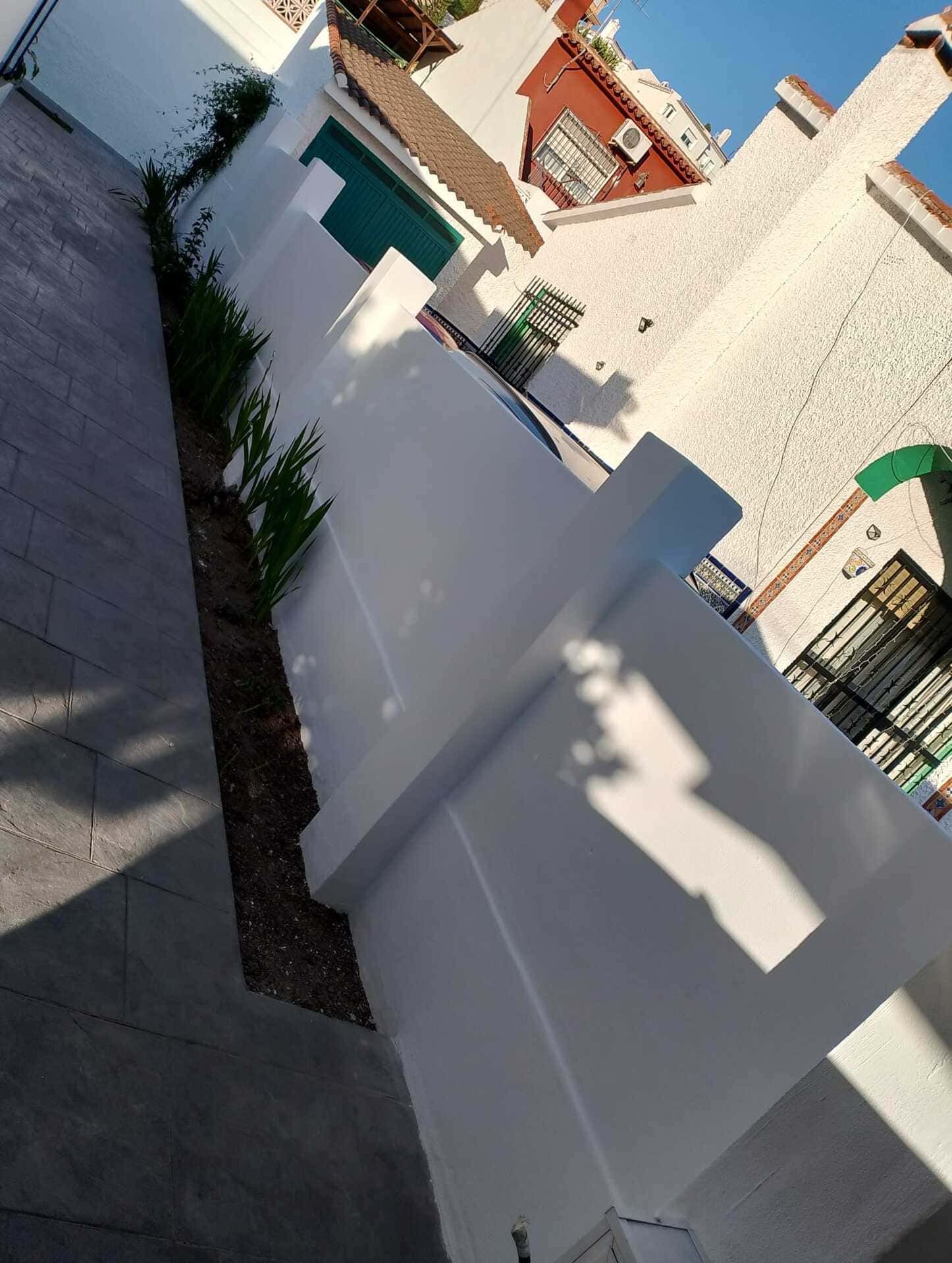 La sombra de una persona se proyecta sobre una valla blanca.