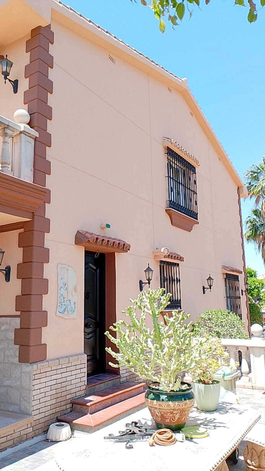 Una casa grande con una mesa y plantas en macetas delante de ella.