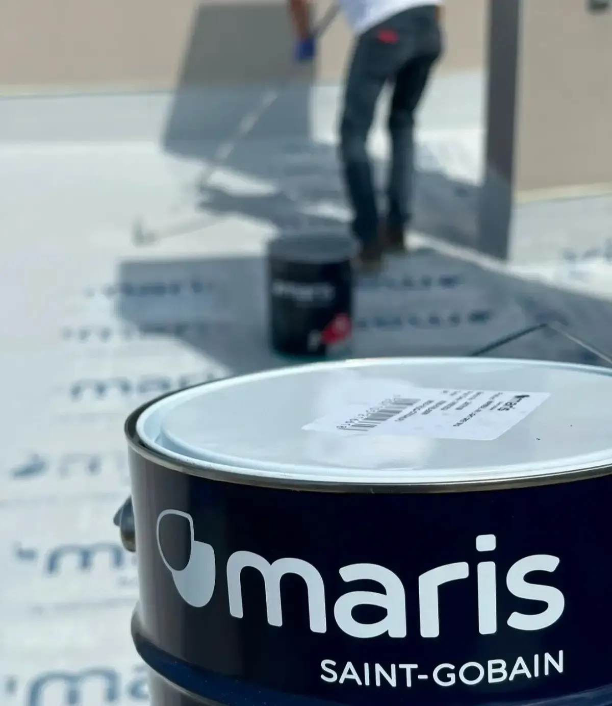 Un hombre está pintando el costado de una casa blanca.