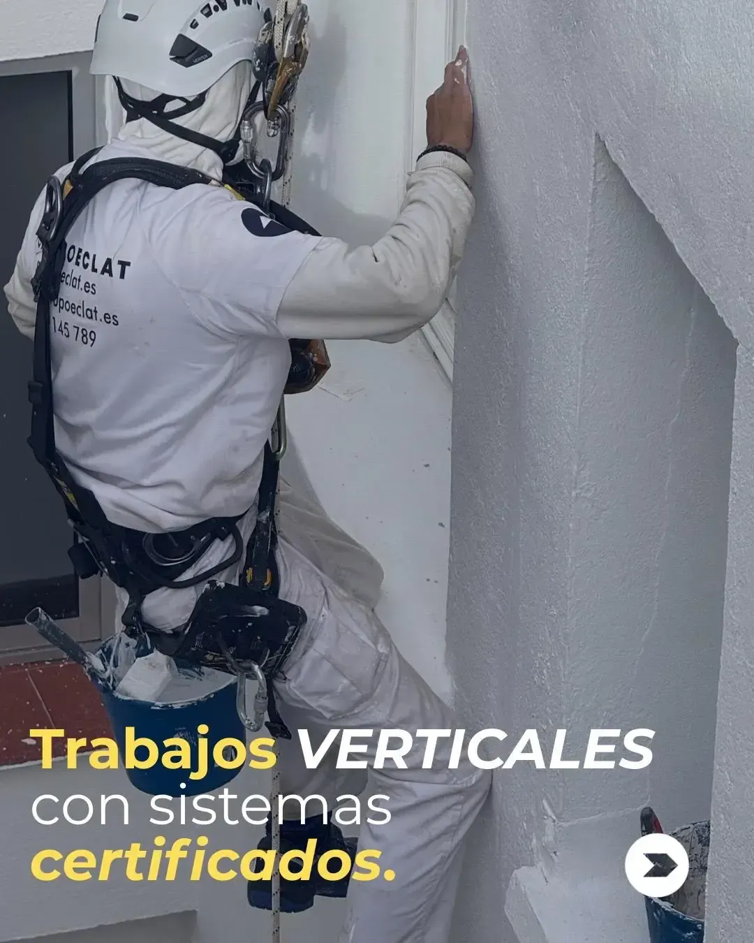 Una casa blanca con un toldo rojo y una escalera de caracol