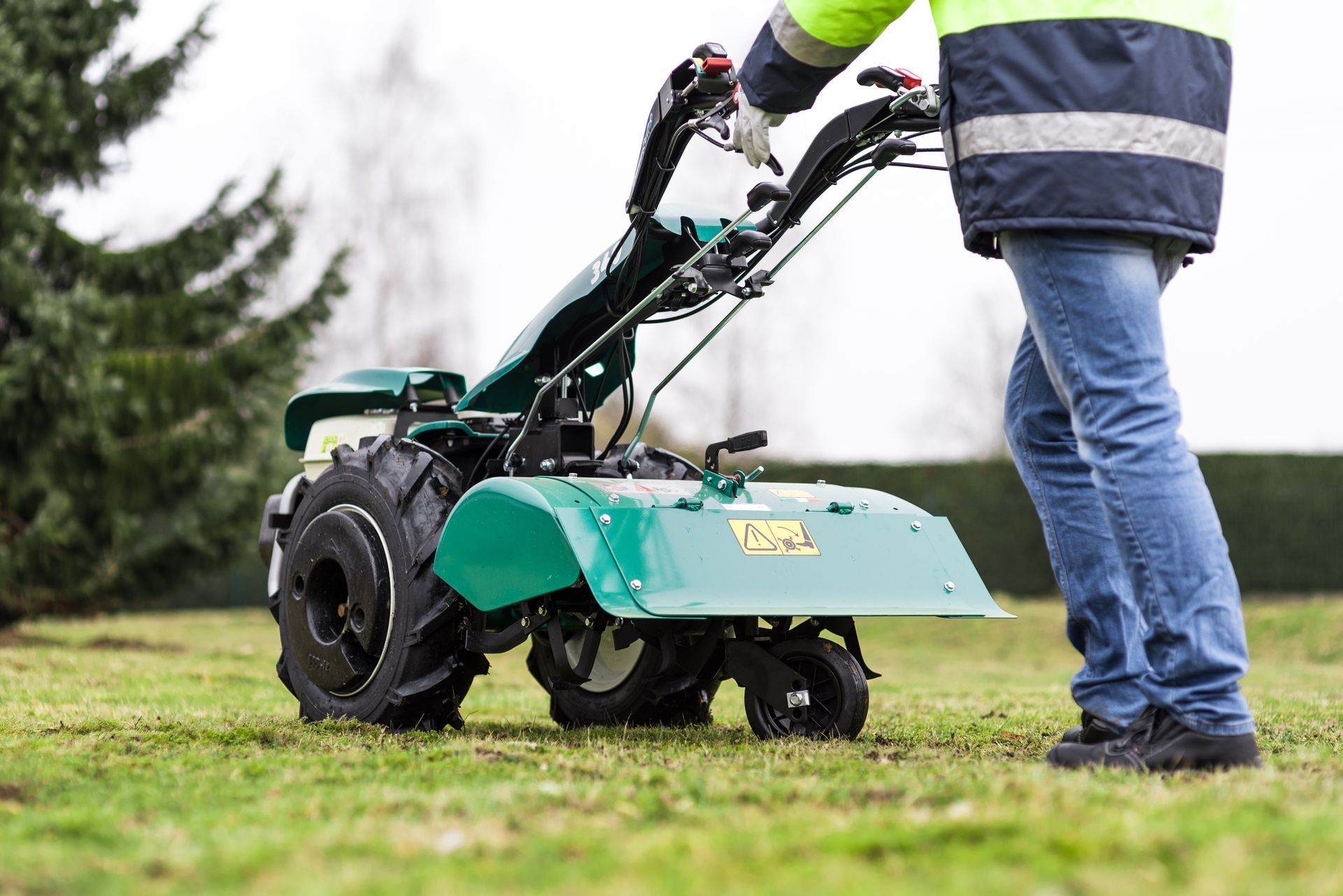 Personne utilisant un motoculteur de pelouse vert sur de l’herbe en plein air