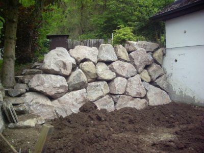 Vor einem Haus liegt ein Steinhaufen.