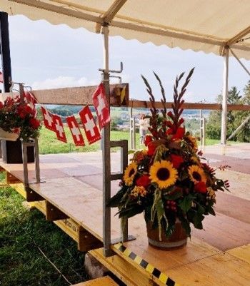 Ein Kranz aus Sonnenblumen und weißen Blumen auf einem Holztisch