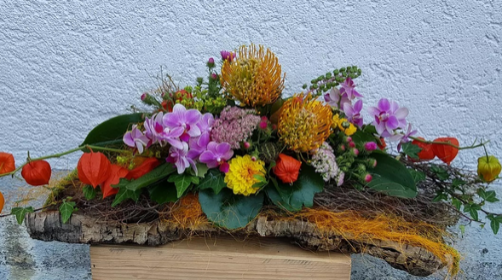 Auf einer Holzkiste steht ein Blumenstrauß.