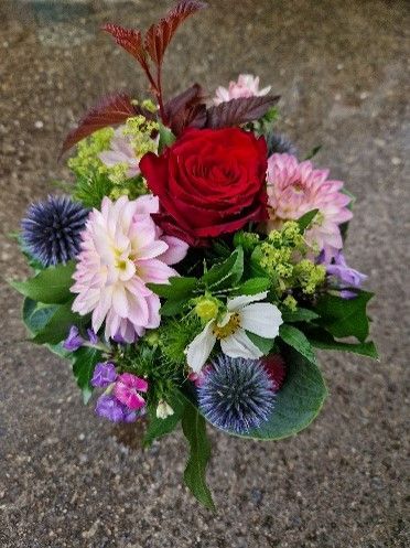 Ein Blumenstrauß steht auf einer Betonfläche.