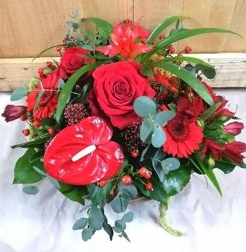 Ein Strauß roter Blumen, darunter Rosen und Anthurien