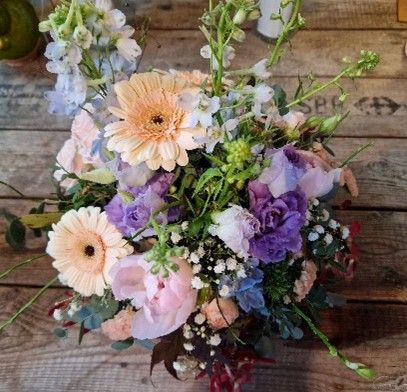 Auf einem Holztisch steht ein Blumenstrauß.