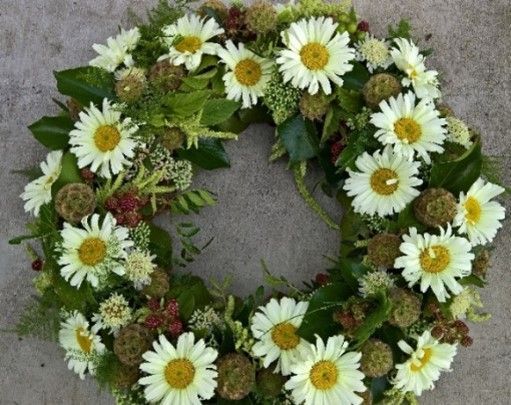 Ein Kranz aus weißen Gänseblümchen mit gelber Mitte