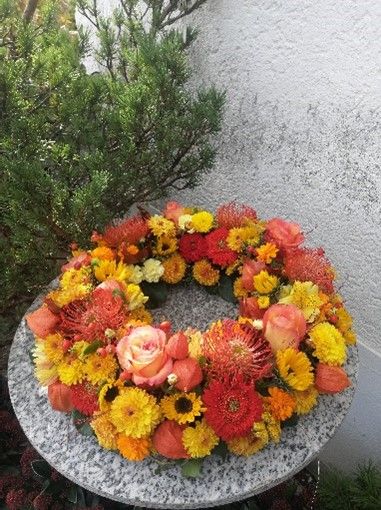 Auf einem Tisch steht ein Blumenkranz.