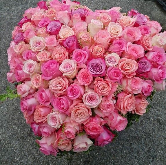 Ein herzförmiger Strauß rosa Rosen auf dem Boden