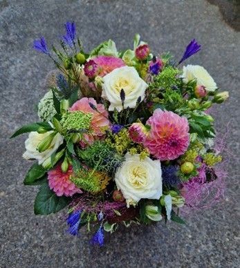 Ein Blumenstrauß steht auf einer Betonfläche.