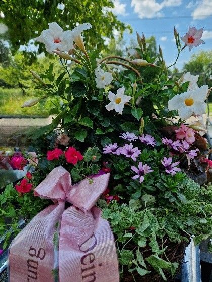 Ein Blumenstrauß mit einer rosa Schleife mit der Aufschrift „Dein“