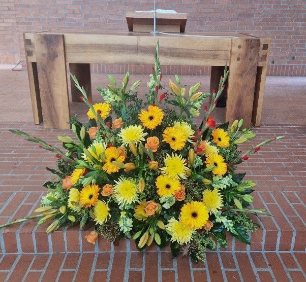 Ein Strauß gelber Blumen auf einem Ziegelboden