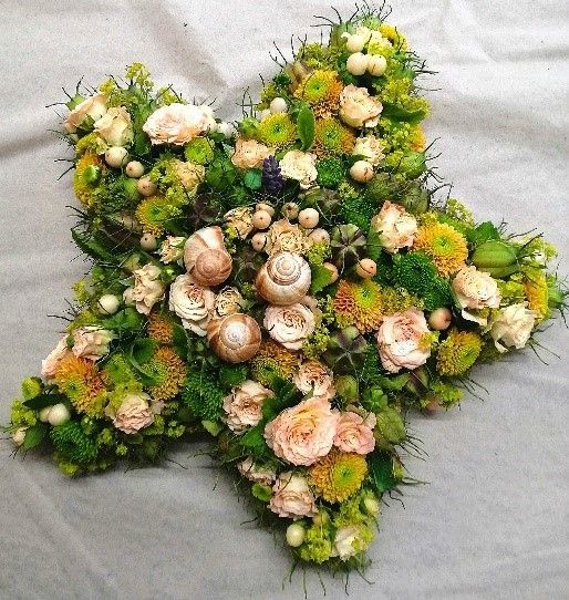 Ein Stern aus Blumen und Grün auf einem Tisch