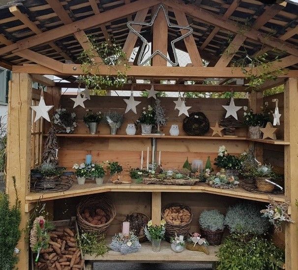 Ein Holzregal voller Topfpflanzen und Kerzen