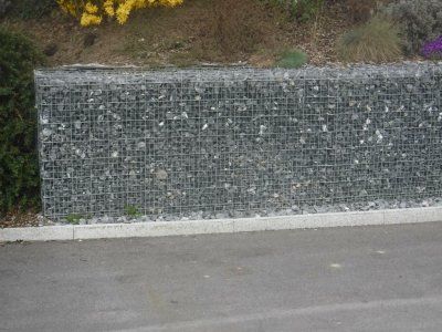 Eine Steinmauer am Straßenrand neben einer Straße.