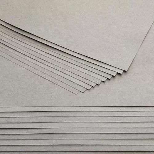 Un primer plano de una pila de láminas de cartón apiladas una encima de otra.