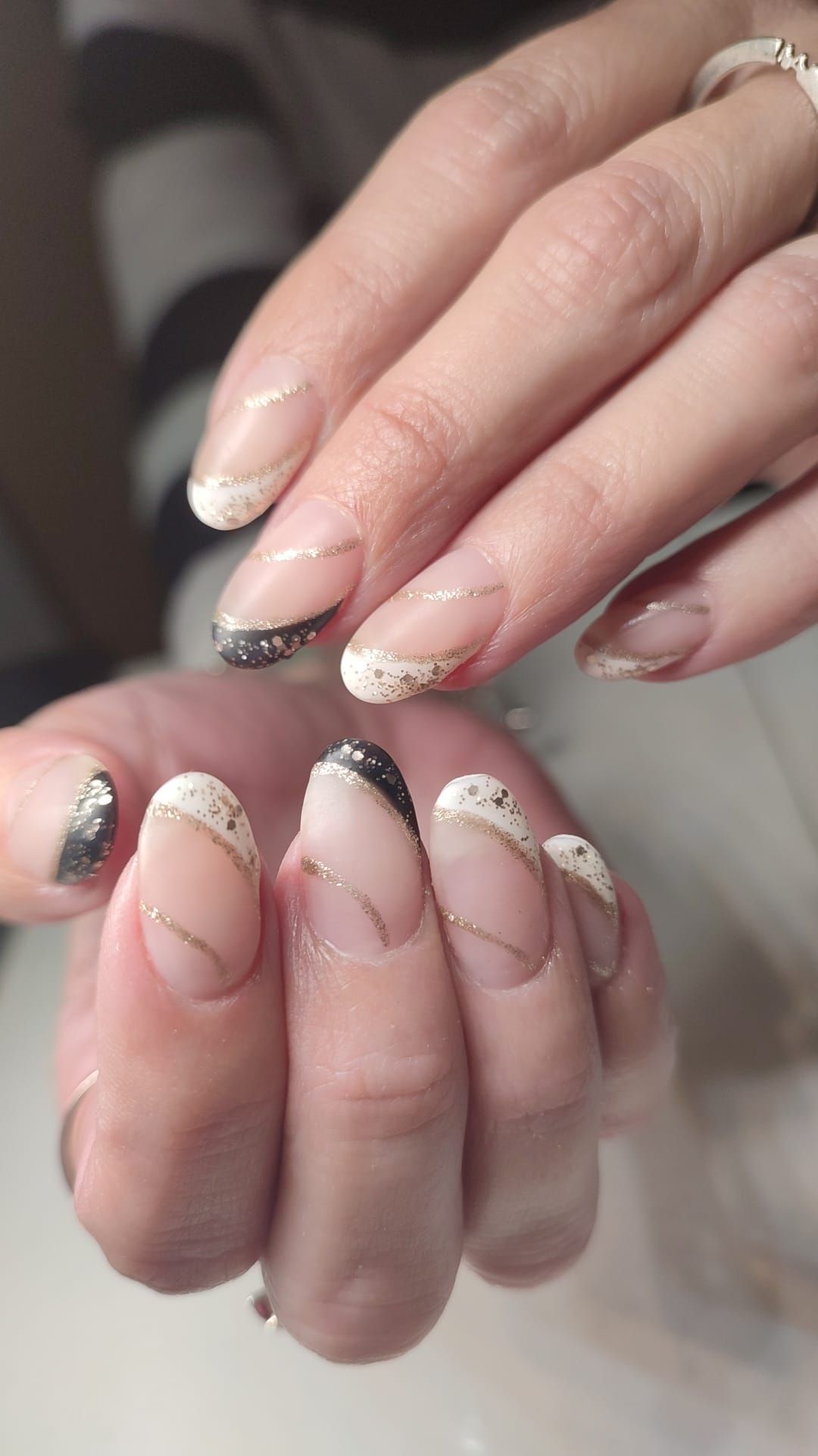 Un primer plano de las uñas de una mujer con manicura francesa.