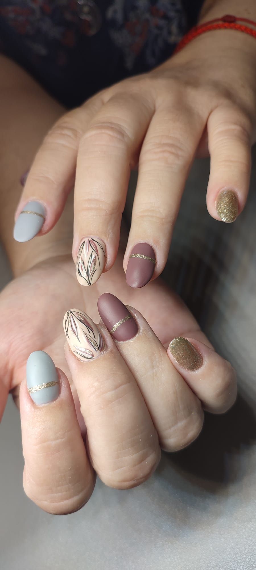 Un primer plano de las uñas de una mujer con diferentes colores y diseños.