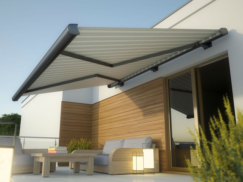 Au coucher du soleil, un store rétractable beige s'étend au-dessus d'une terrasse moderne aux murs lambrissés et meublée de mobilier de jardin.