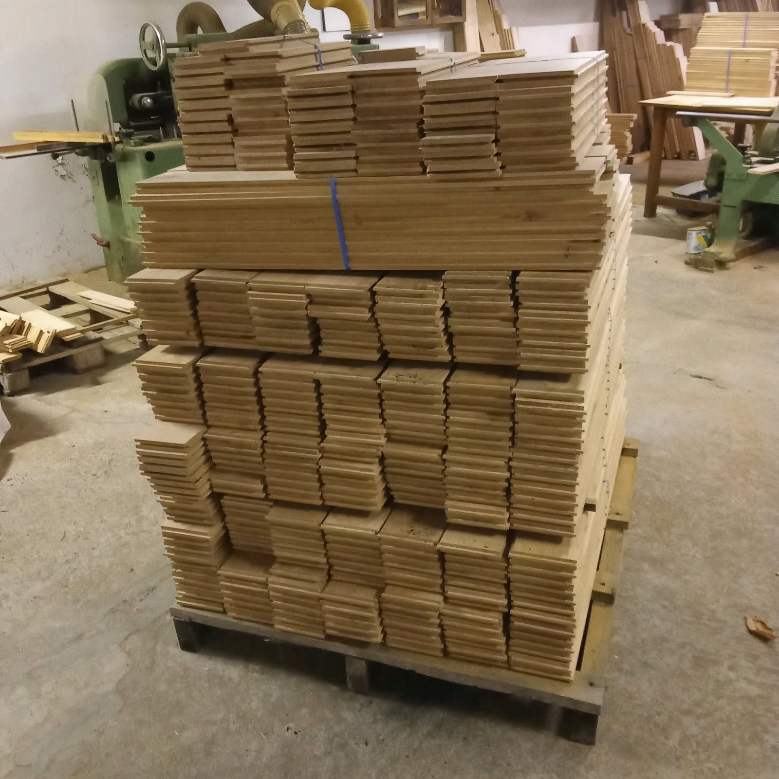 Une personne tenant un éventail d'échantillons de parquet de couleurs variées, à l'intérieur.