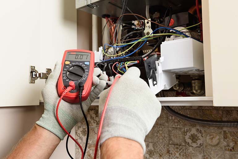 Technicien utilisant un voltmètre
