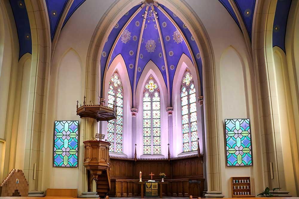 Eine Kirche mit blauer Decke und Buntglasfenstern