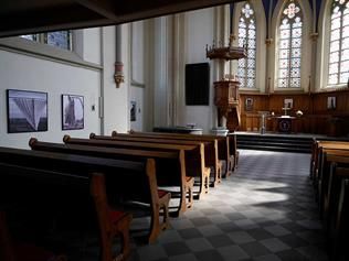 Das Innere einer Kirche mit Bankreihen und einem Podium.