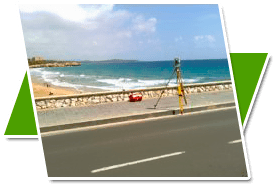Una imagen de una playa con una carretera en primer plano.