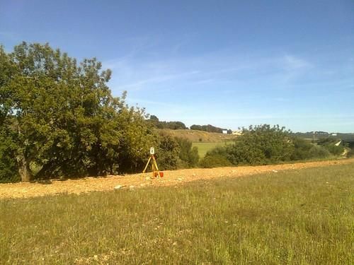 Un trípode está sentado en el medio de un campo de hierba.