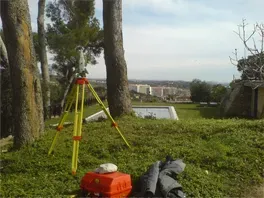 Un trípode está sentado en el medio de un campo de hierba.
