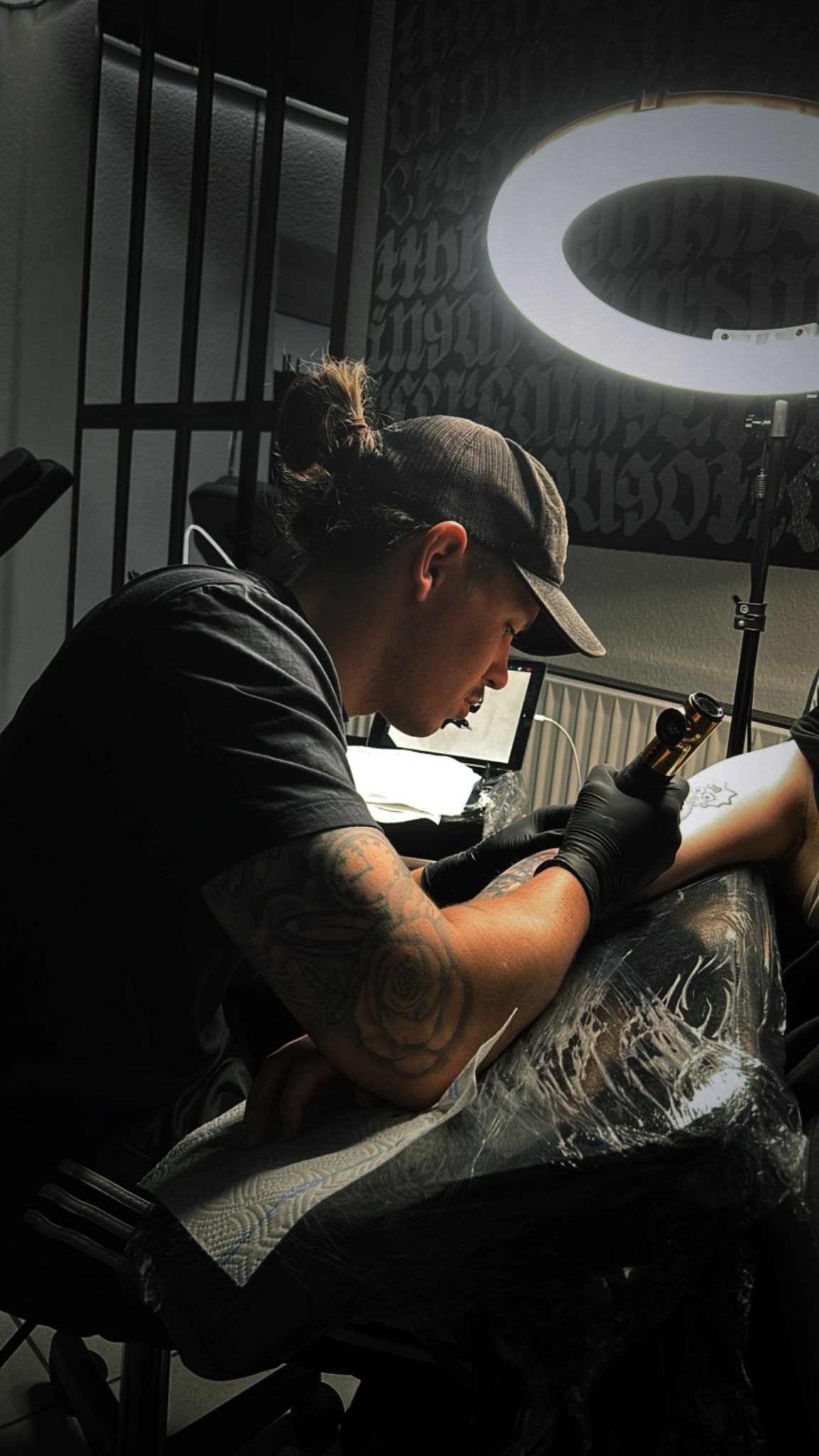 Ein Mann lässt sich auf den Arm eines anderen Mannes tätowieren.