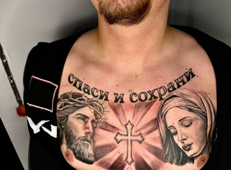 Ein Mann hat eine Tätowierung von Jesus und Maria auf seiner Brust
