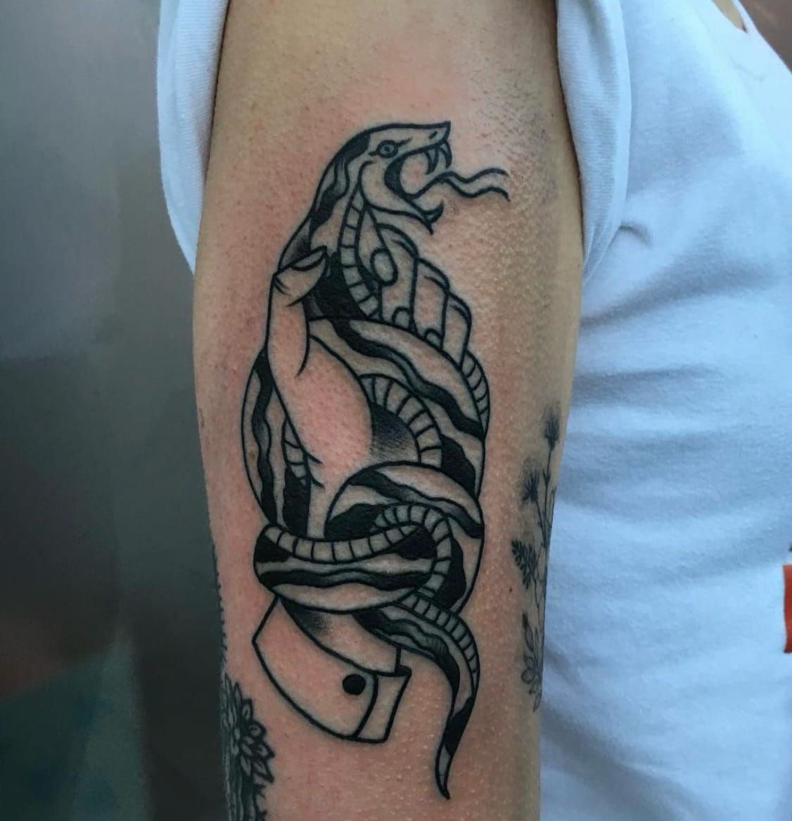 Eine Frau hat eine Schlangentätowierung auf ihrem Arm