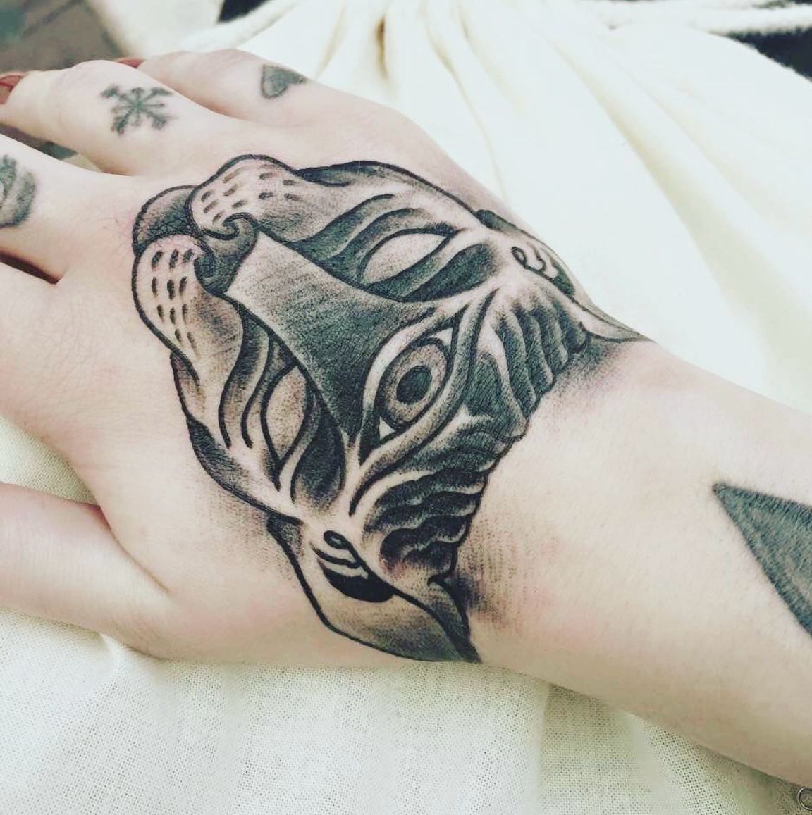 Eine Person hat eine Katzentätowierung auf der Hand