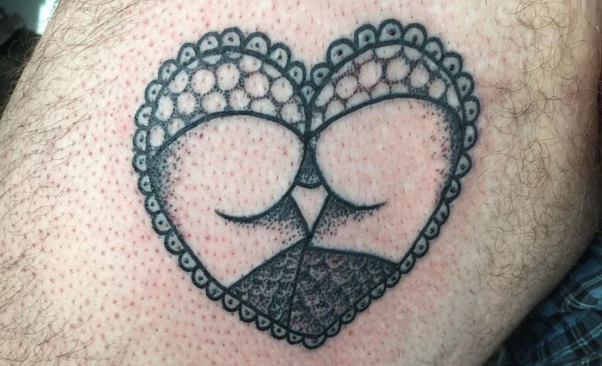 Eine Person hat eine herzförmige Tätowierung auf ihrem Bein.