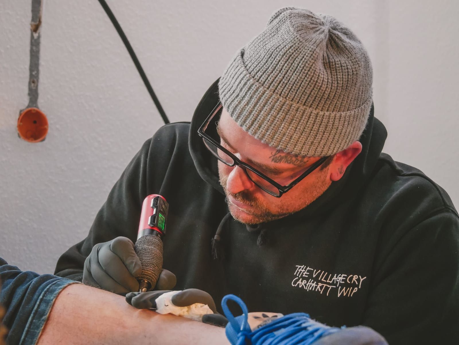 Ein Mann lässt sich auf den Arm eines anderen Mannes tätowieren.