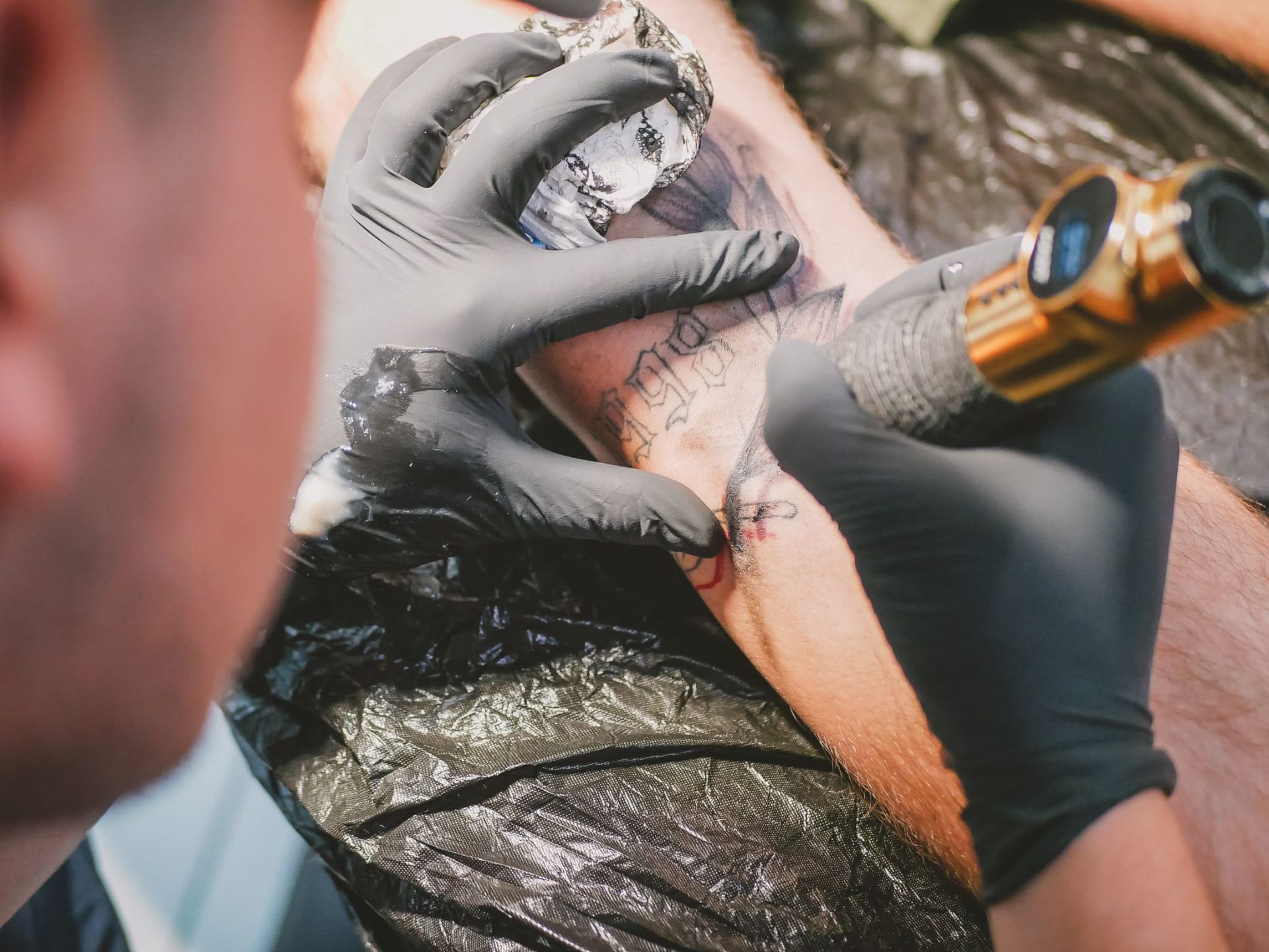 Ein Mann lässt sich ein Tattoo auf den Arm machen.