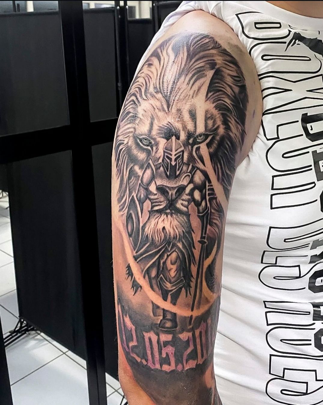 Ein Mann hat ein Löwentattoo auf seinem Arm