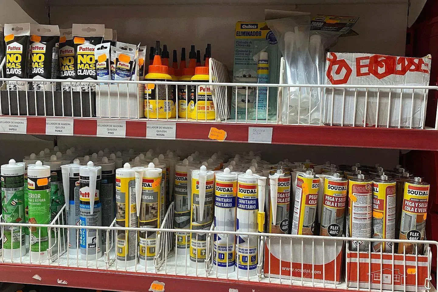 Un estante de tienda lleno de muchos tipos diferentes de pegamento