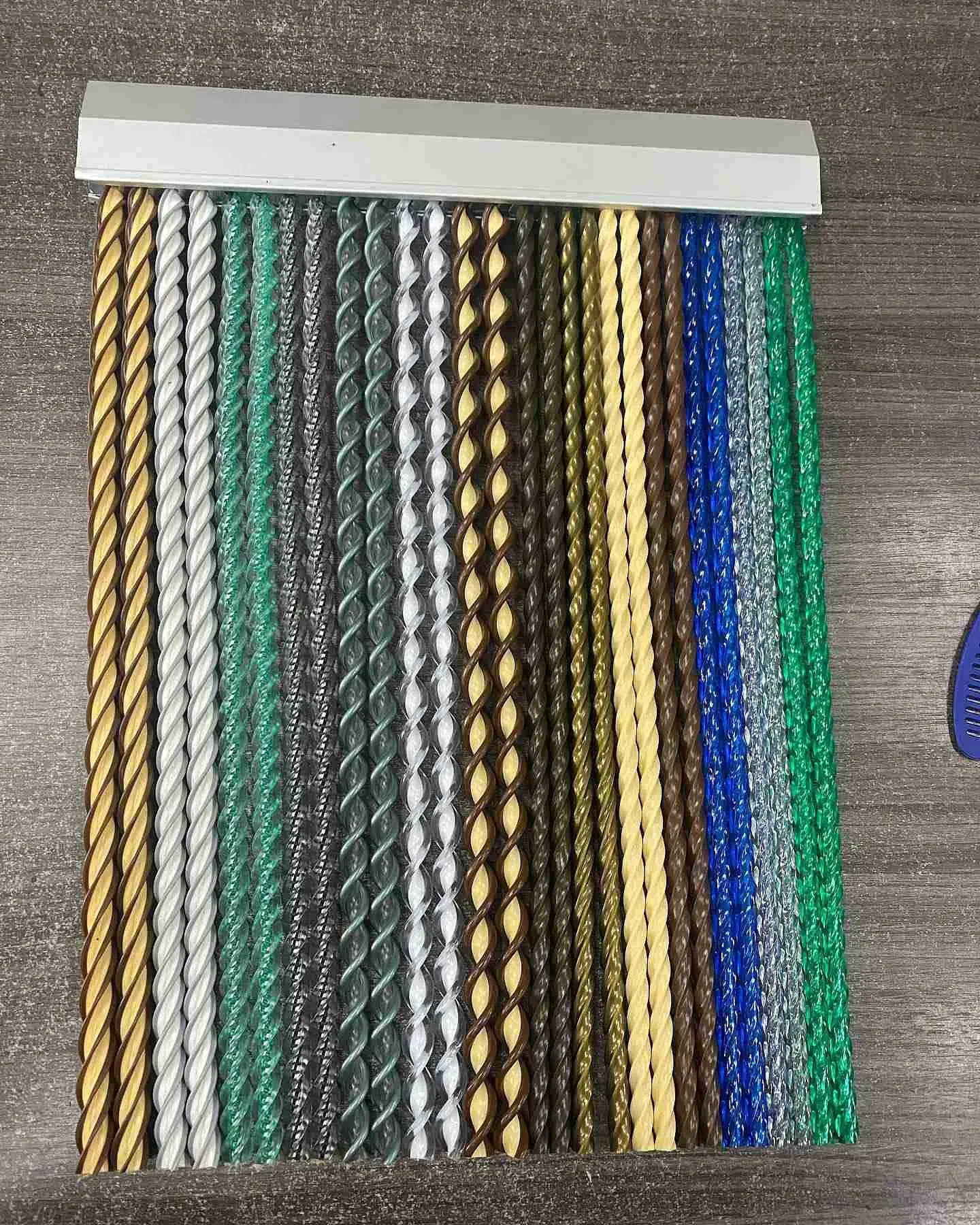 Un montón de cuerdas de diferentes colores están sobre una superficie de madera.