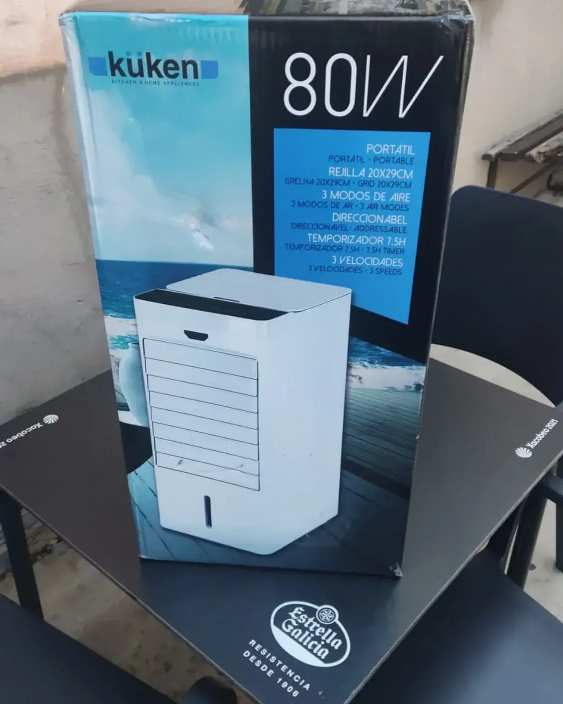 Un enfriador de aire Kuken de 80 W está sobre una mesa junto a su caja.