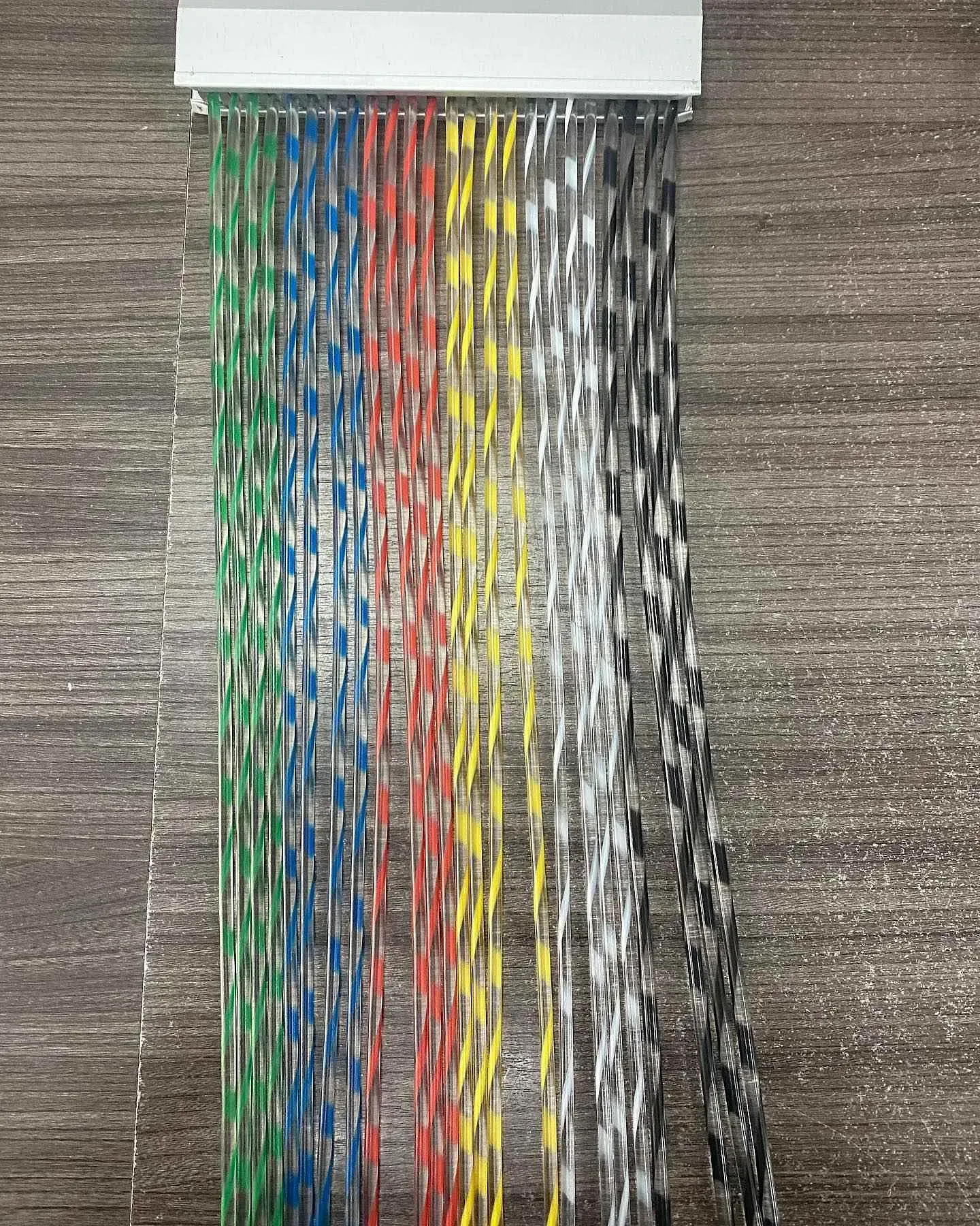 Un montón de cuerdas de colores están sobre una mesa de madera.