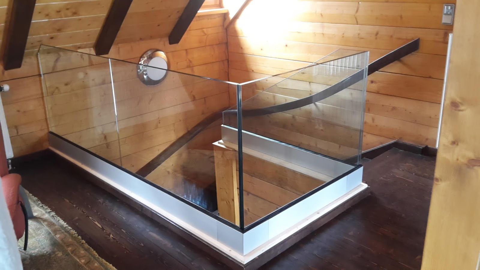 Eine Treppe mit einem Glasgeländer in einem Holzhaus