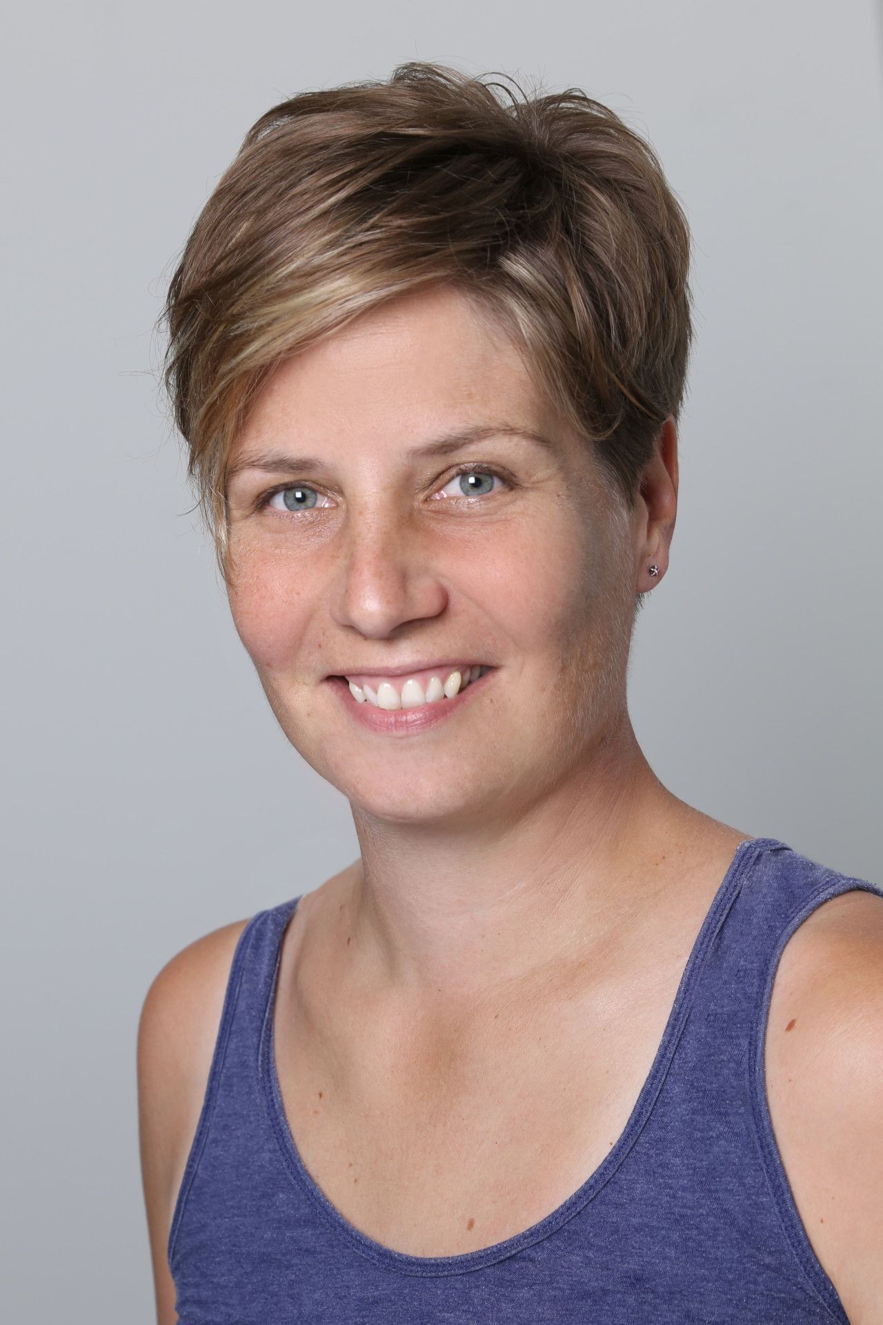 Hände massieren den oberen Rücken und die Schulter einer Person auf einem weissen Handtuch.