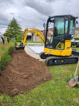 Une tractopelle met en place de la terre végétale