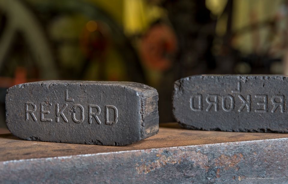 Auf den Gleisen steht ein mit Kohle beladener Waggon. Sattler Bau- und Handels GmbH