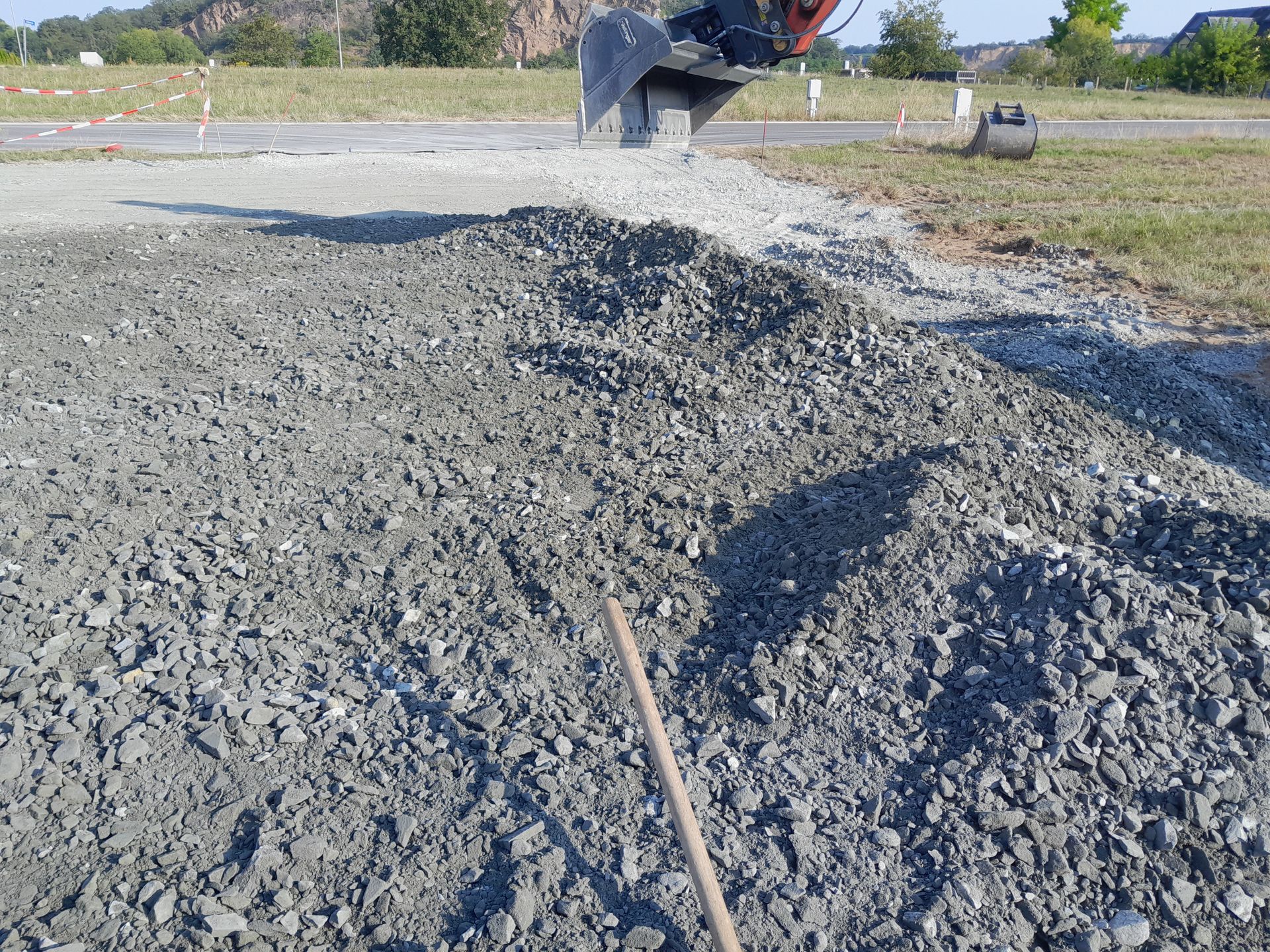 Ein gelber Bagger reißt auf einer Baustelle ein Gebäude ab. Sattler Bau- und Handels GmbH