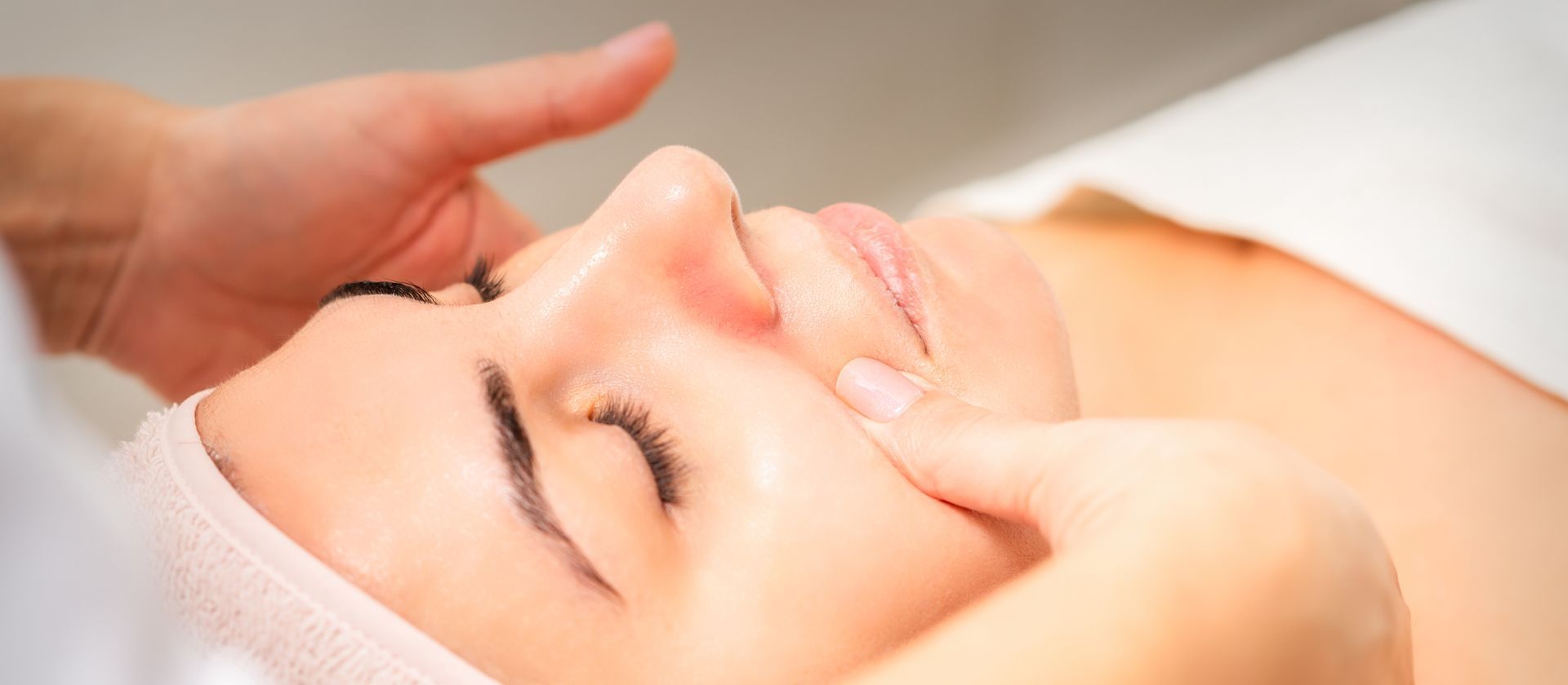 Una donna si sta sottoponendo a un massaggio facciale in una spa.