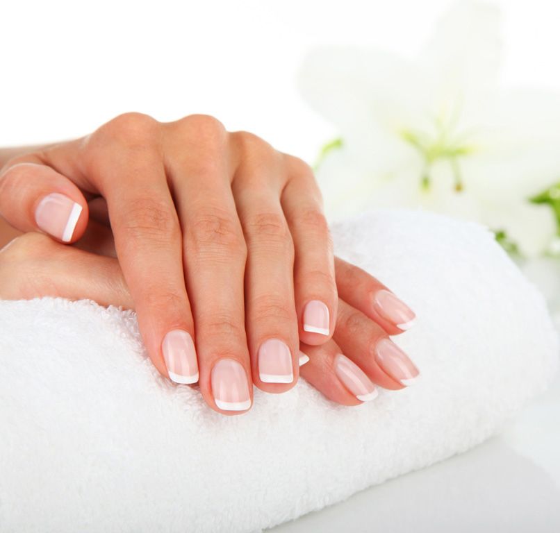 Le mani di una donna sono appoggiate su un asciugamano bianco.